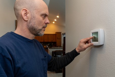 Person Examining Thermostat